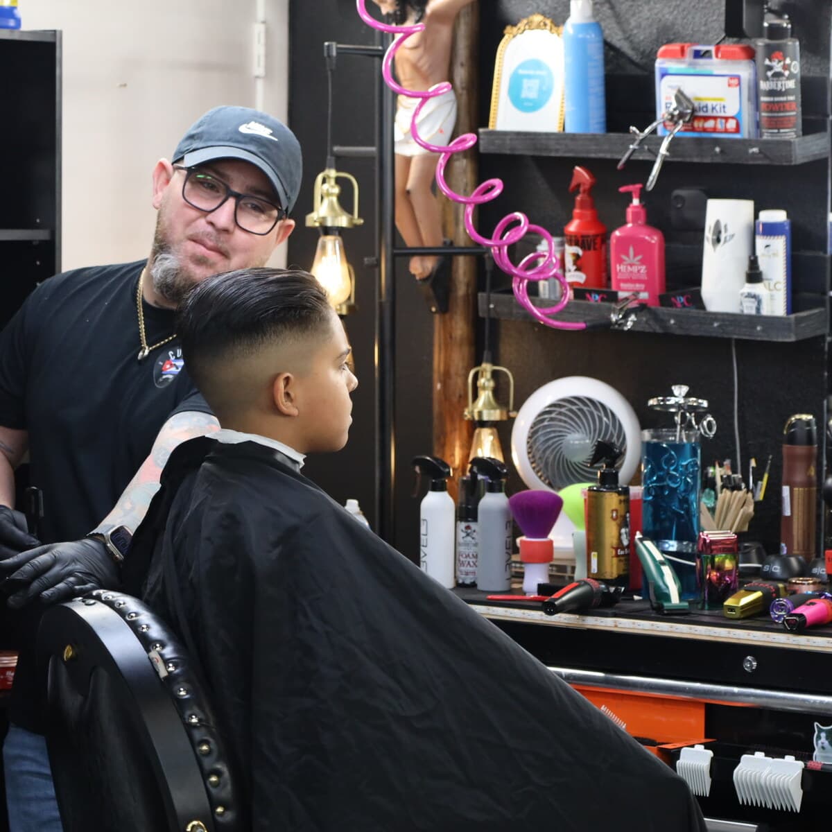 Adriano beside a finished mid fade on a young client at Tu Barber Cubanito in Brighton